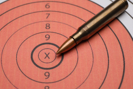 Firearm cartridge on paper target, closeup view