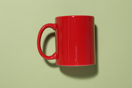 Red mug on light green background, top view. Mockup for designの写真素材