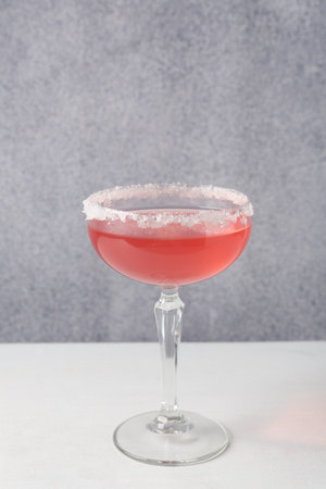 Martini cocktail with sugar in glass on white table near grey wallの写真素材