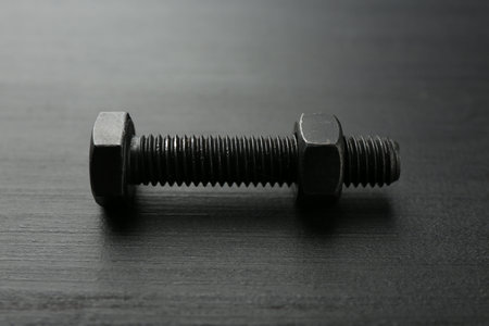 One metal bolt on dark wooden table, closeupの写真素材