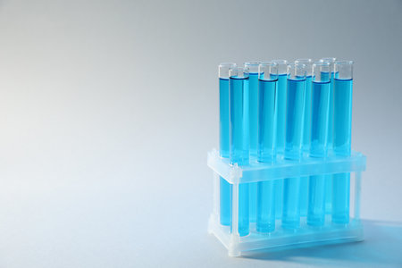 Test tubes with blue liquid on light background, closeup. Space for textの写真素材
