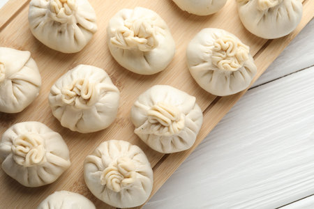 Uncooked khinkalis (dumplings) on white wooden table, top viewの写真素材