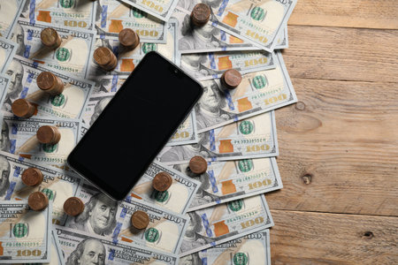 Smartphone and money on wooden table, flat lay