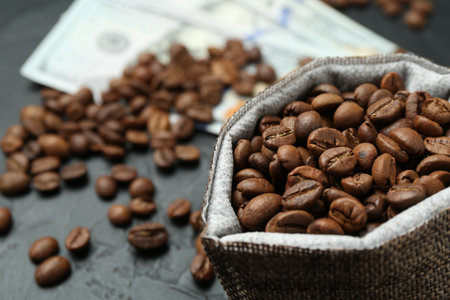 Roasted coffee beans in sack on dark textured table, closeupの写真素材