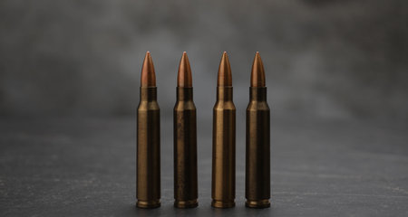 Firearm cartridges on gray table against smoke, closeup