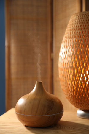 Modern aroma lamp on wooden table indoorsの写真素材