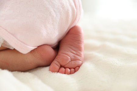 Cute newborn baby lying on bed, closeup.の写真素材