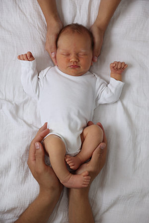 Parents with their cute newborn baby on bed, top view