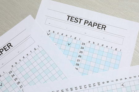 Answer sheets on wooden table, flat lay. Student passing exam
