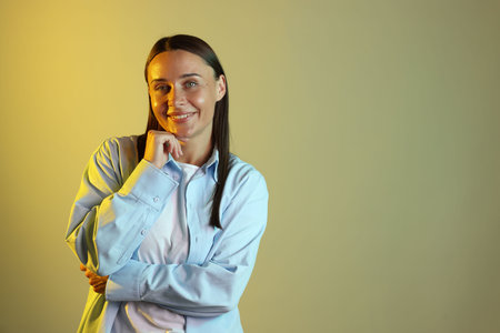Smiling woman in neon lights against color background. Space for textの写真素材