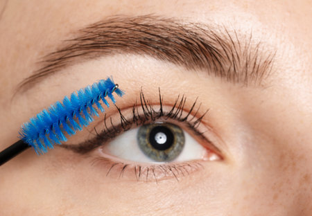 Woman applying mascara onto her eyelashes, closeupの写真素材