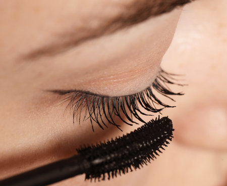 Woman applying mascara onto her eyelashes, closeupの写真素材