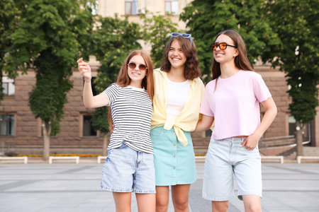 Happy friends walking together on city streetの写真素材