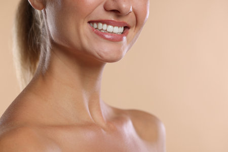 Woman with beautiful healthy teeth on beige background, closeup. Space for textの写真素材