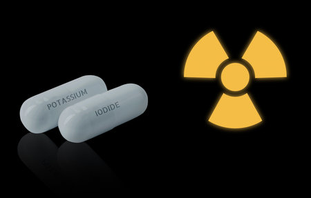 Potassium iodide pills and warning sign on black background. Iodine consumption during radioactive contaminationの写真素材