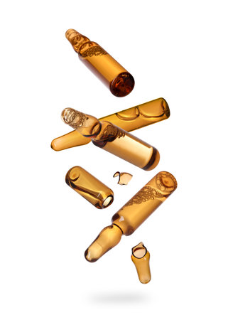 Many ampoules and glass pieces falling on white backgroundの写真素材