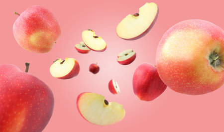 Fresh red apples swirling in air against pink gradient backgroundの写真素材