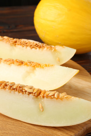 Cut and whole ripe melons on wooden table, closeupの写真素材