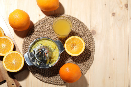 Freshly squeezed orange juice, fruits and juicer on wooden table, flat lay. Space for text