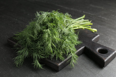 Bunch of fresh dill on black table, closeup