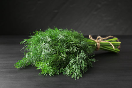 Bunch of fresh dill on black table, closeup