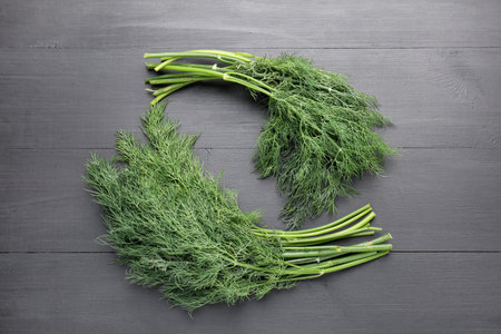Bunch of fresh dill on black wooden table, flat layの写真素材