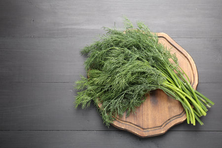 Bunch of fresh dill on black wooden table, top view. Space for textの写真素材