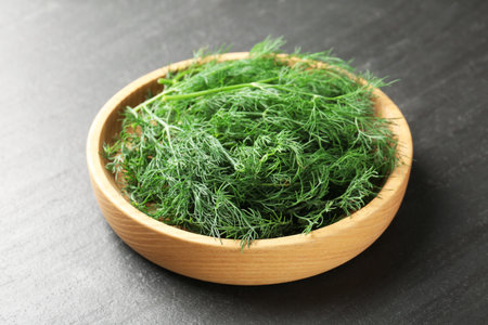 Fresh dill in bowl on black table, closeupの写真素材