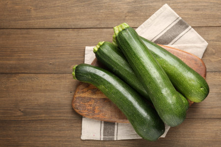 Fresh ripe zucchinis on wooden table, top view. Space for textの写真素材