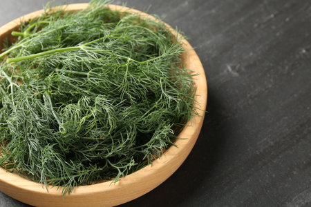 Fresh dill in bowl on black table, closeup. Space for textの写真素材