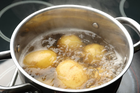 Young potatoes boiling in pot on stove, closeupの写真素材