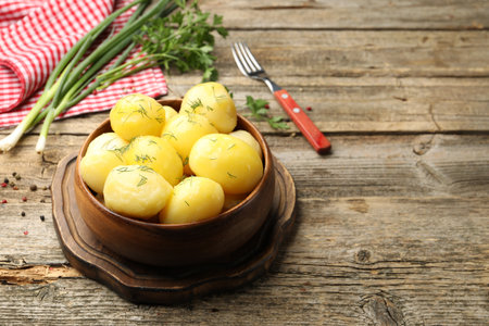 Tasty young boiled potatoes with dill on wooden table. Space for textの写真素材