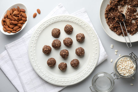 Making tasty chocolate candies. Bonbons and ingredients on white table, flat lay