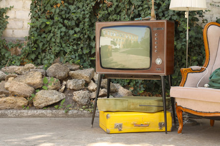Retro TV on stand, suitcases and other used stuff outdoorsの写真素材