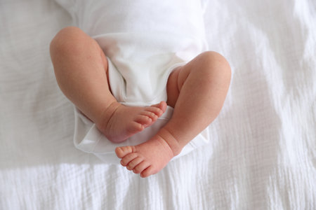 Cute newborn baby lying on bed, top viewの写真素材