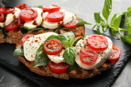 Delicious sandwiches with mozzarella cheese, tomatoes and basil on table, closeupの写真素材