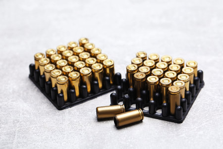 Many metal cartridges on gray table, closeup