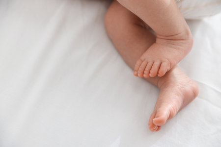 Cute newborn baby lying on bed, above view. Space for textの写真素材