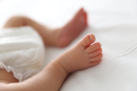 Cute newborn baby lying on bed indoors, closeupの写真素材