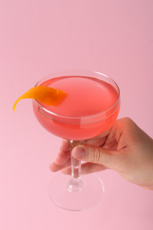 Woman with cocktail on pink background, closeupの写真素材