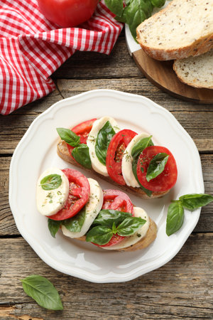 Delicious sandwiches with mozzarella cheese, tomatoes and basil on wooden table, flat layの写真素材
