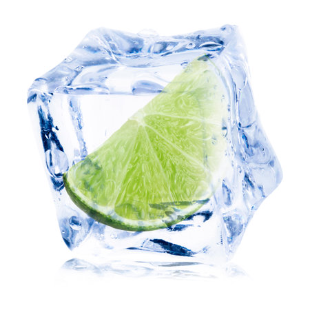 Fresh lime wedge in ice cube isolated on whiteの写真素材