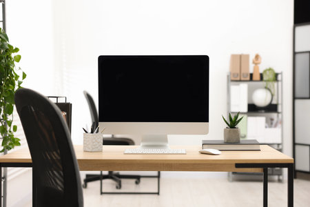 Stylish workplace with modern computer and stationery on wooden table in officeの写真素材