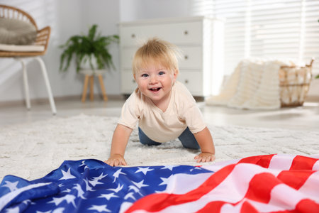 Cute little child with flag of USA on floor at homeの写真素材