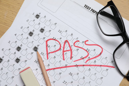 Answer sheet with word Pass, eraser, pencil and glasses on table, top view. Student passing examの写真素材