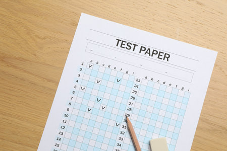 Answer sheet, eraser and pencil on wooden table, flat lay. Student passing examの写真素材