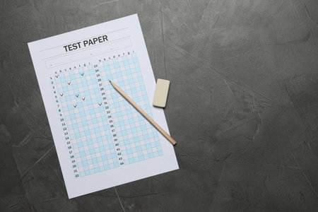 Student passing exam. Answer sheet, pencil and eraser on gray textured table, flat lay. Space for textの写真素材