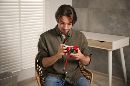 Dreams come true. Man with new gifted camera at home