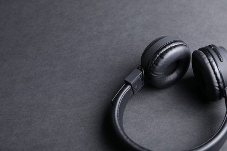 Pair of stylish headphones on black background, closeup. Space for textの写真素材