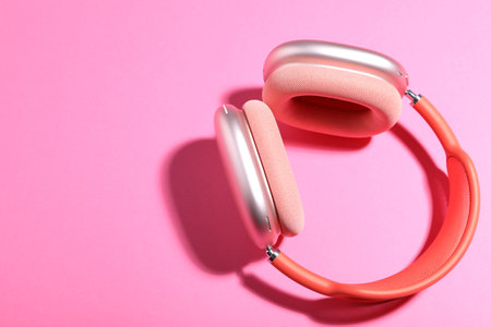Pair of stylish headphones on pink background, top view. Space for textの写真素材